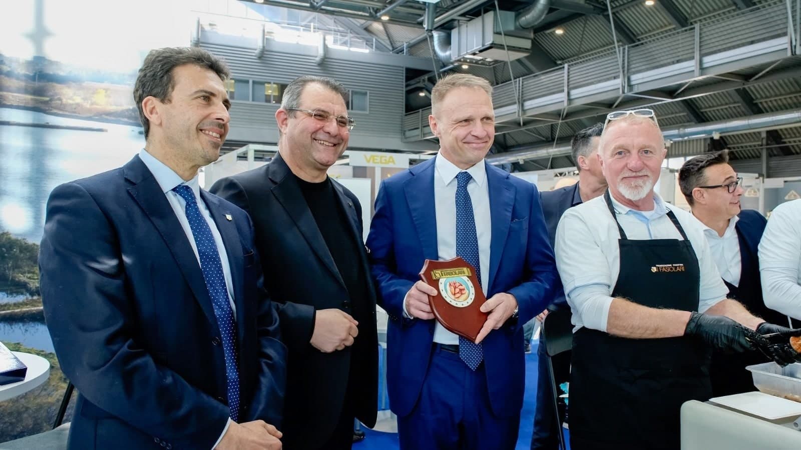 Il gruppo dell'O.P. I Fasolari allo stand della Regione del Veneto ad AquaFarm 2023, con la targa dell'organizzazione