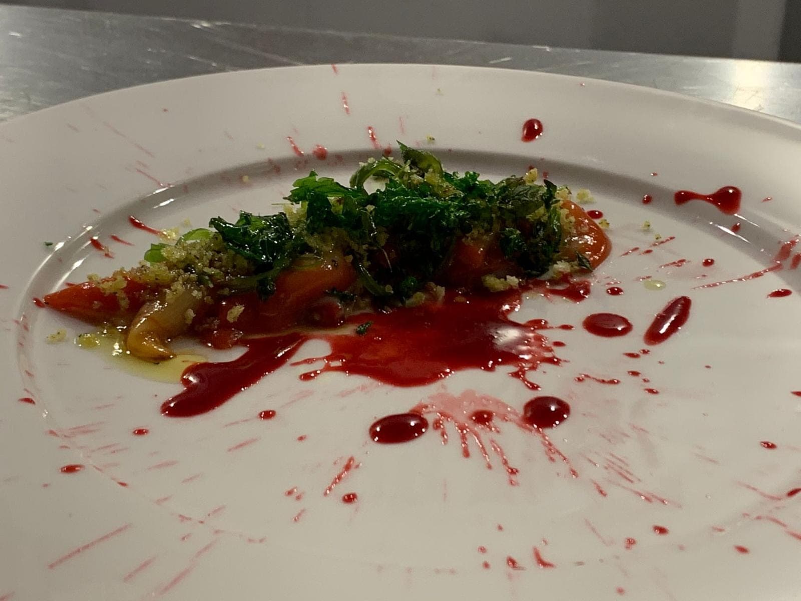 Un piatto gourmet con fasolari, erbe e salsa alla barbabietola