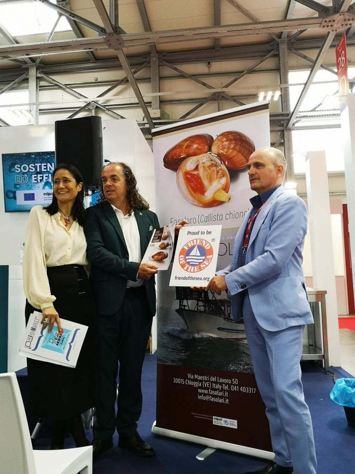 Tre relatori mostrano la brochure del progetto accanto al roll-up