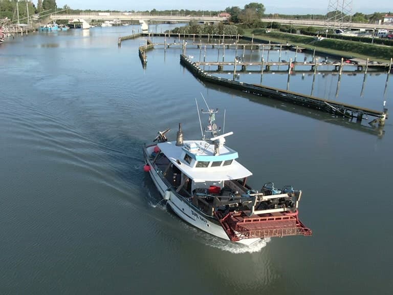 Un peschereccio rientra lungo il canale verso il porto