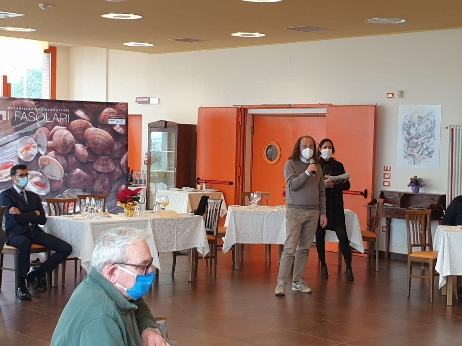 La sala dell'evento con una relatrice davanti al pannello de I Fasolari
