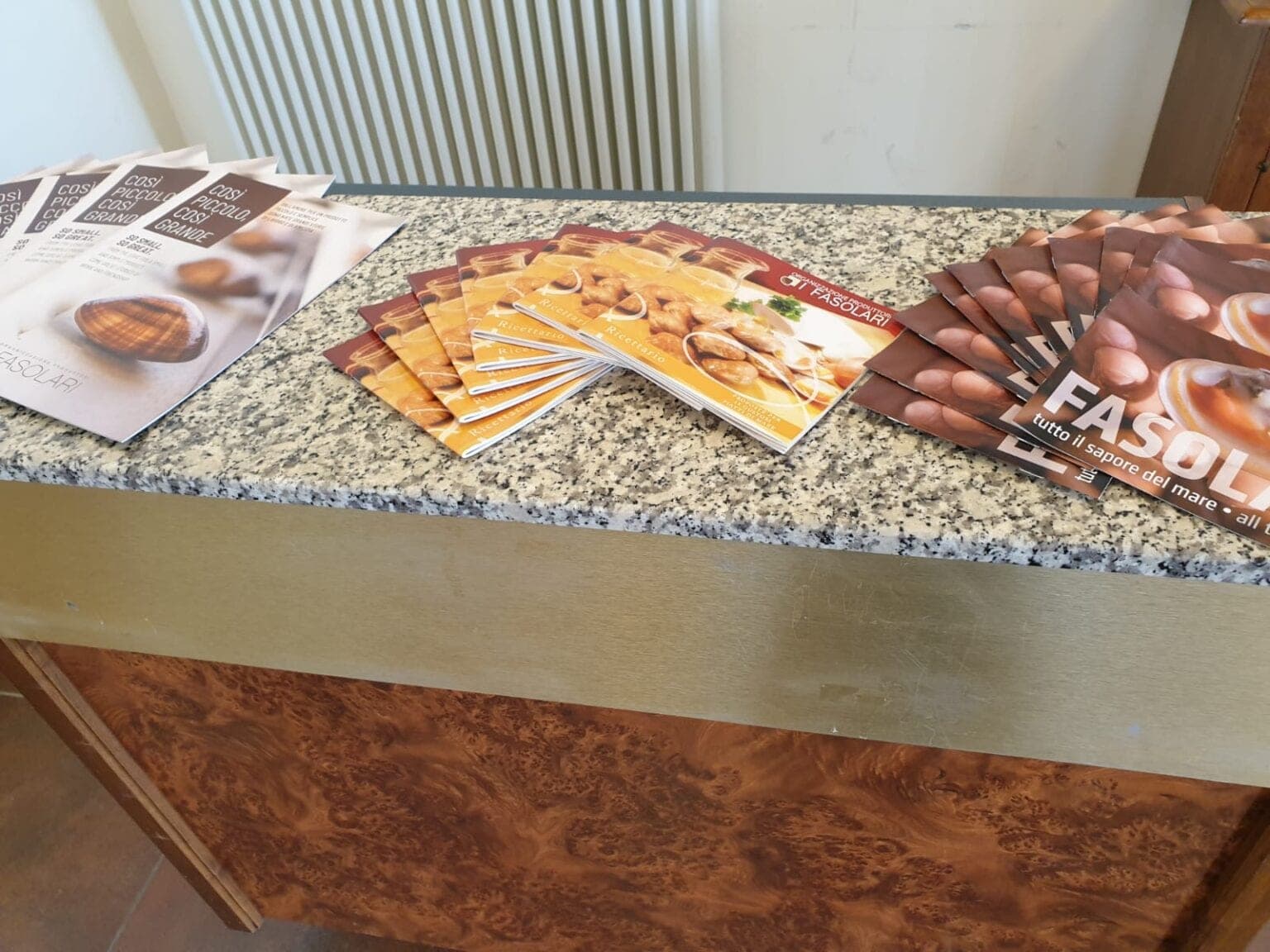 Le brochure e i materiali informativi de I Fasolari esposti su un banco