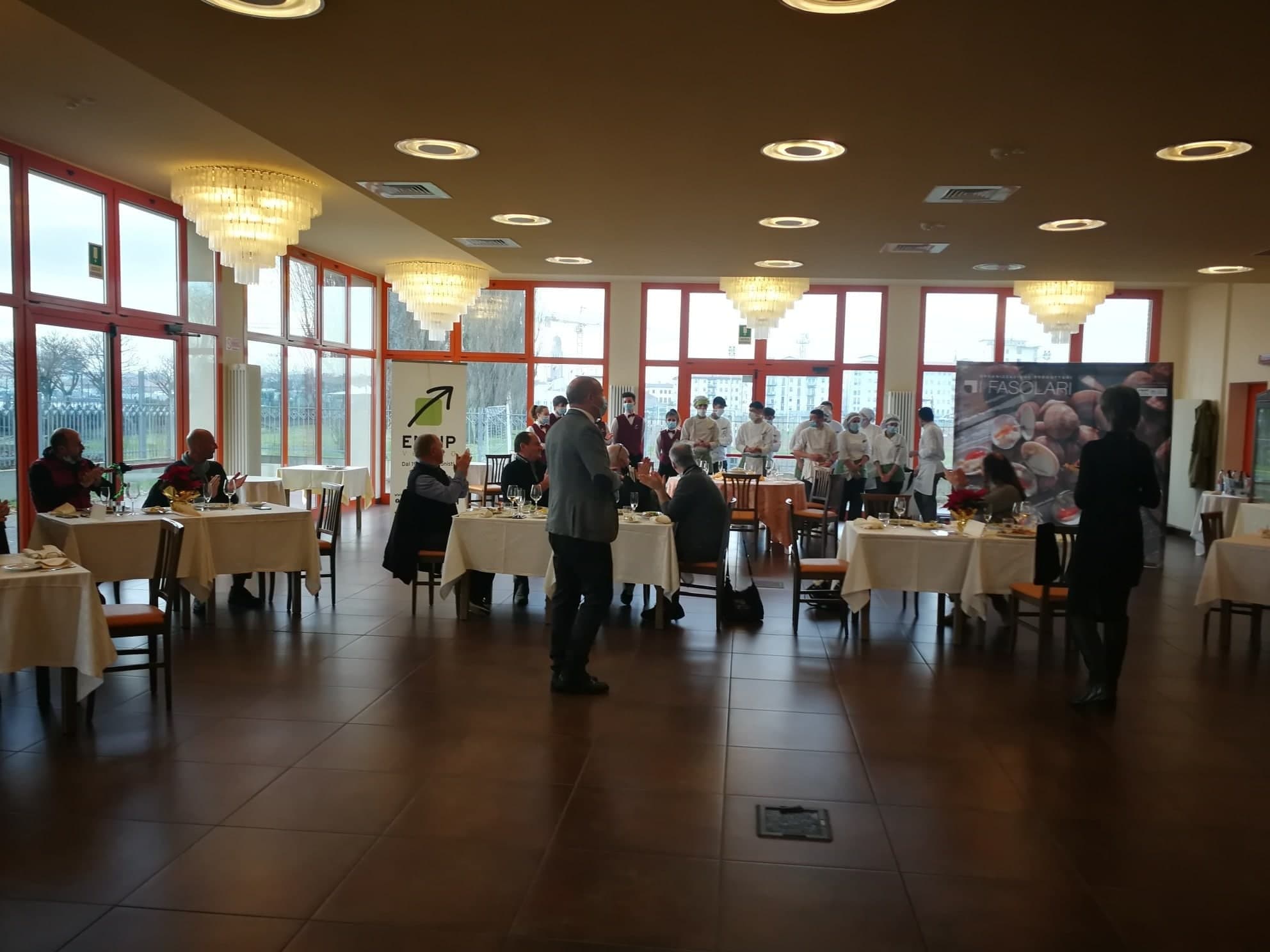 La sala dell'evento con i tavoli apparecchiati e i partecipanti
